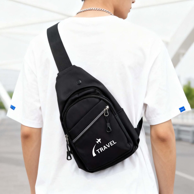 A black sling bag with a logo, featuring multiple zippered compartments, worn across the back of a person.