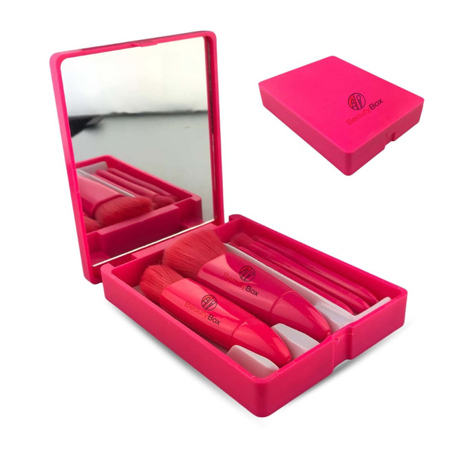 A set of five pink brushes in a plastic mirror box, featuring a reflective interior surface.