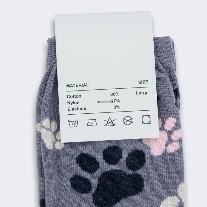 Jolly knitted kids' socks in grey with colourful paw prints, featuring a label with material and size information.