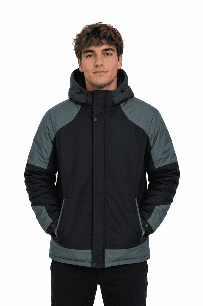 A man wearing a black and grey jacket with a hood, featuring a zip front and side pockets.