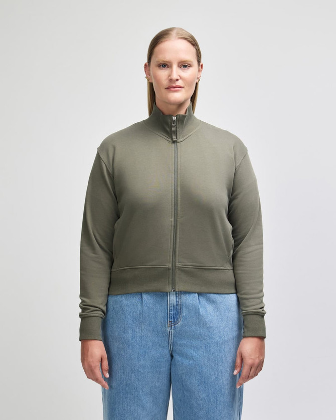 A women's full-zip jacket in olive green, featuring a high collar and ribbed cuffs, with a logo visible.