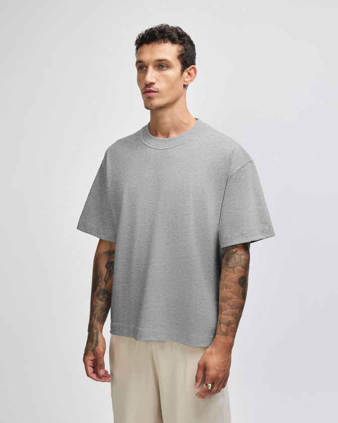 A grey heavyweight cotton unisex boxy t-shirt displayed on a model, featuring short sleeves and a relaxed fit.