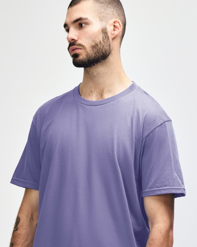 A purple Gildan Softstyle adult midweight T-shirt displayed on a model, featuring a logo on the chest.