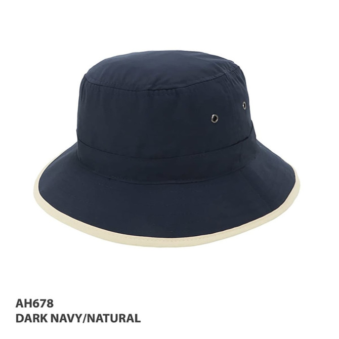 A dark navy bucket hat with a natural trim and ventilation eyelets, featuring a logo.