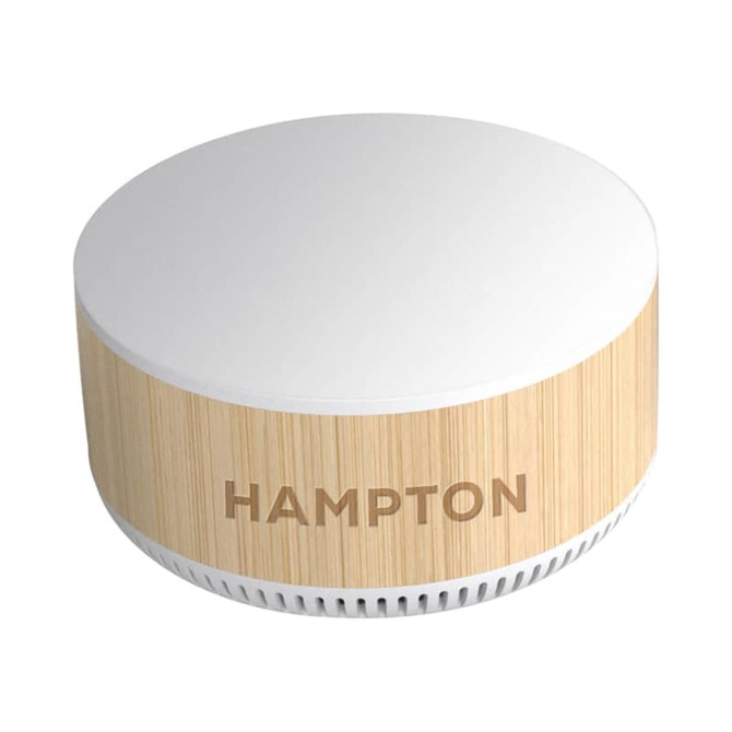 A round, wooden-textured wireless charging speaker in cream and light beige, featuring a brand logo.