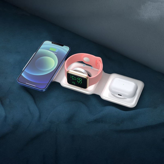 A white 3-in-1 wireless charger displaying a smartphone, smartwatch, and earbuds on a blue surface.