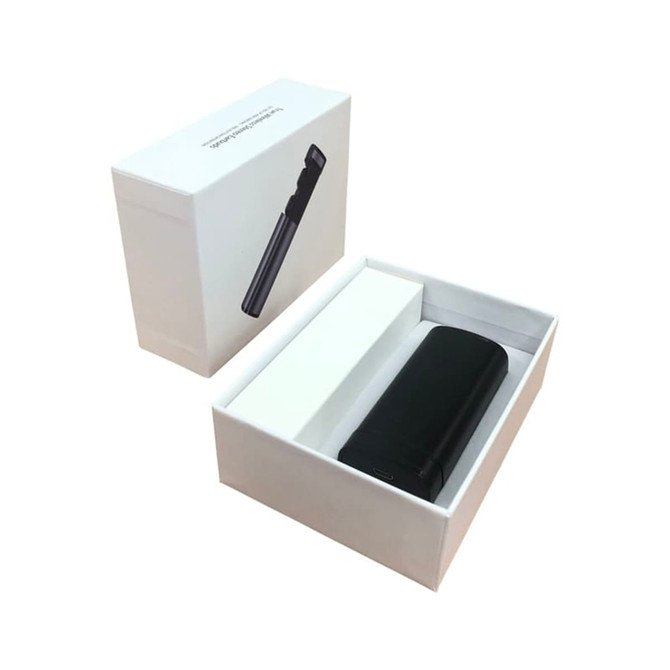 A black charging case for earbuds sits inside a white box, featuring a sleek design and minimalistic packaging.