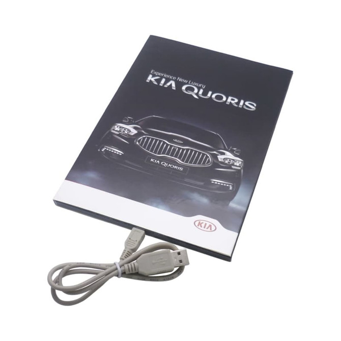A promotional brochure for the Kia Quoris with a USB cable included. The cover features a dark design with a car image.
