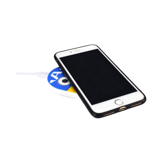 A wireless charger in white and blue with a smartphone placed on top, connected by a charging cable.