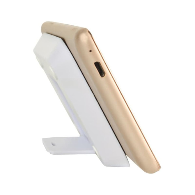 A gold phone is resting on a white wireless charger stand, angled for optimal charging. The stand includes a logo.