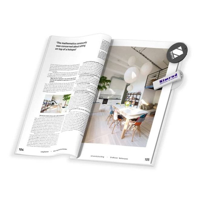 An open magazine with a white background, showcasing text and images, including a table and balloons.