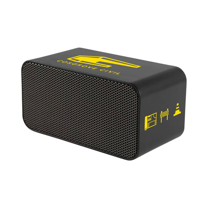 A black wireless charging speaker with a textured front, featuring a yellow logo and icons.