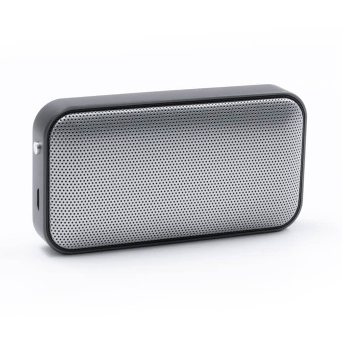 A compact black and silver wireless speaker with a mesh front design and a side port. It features a logo on the surface.