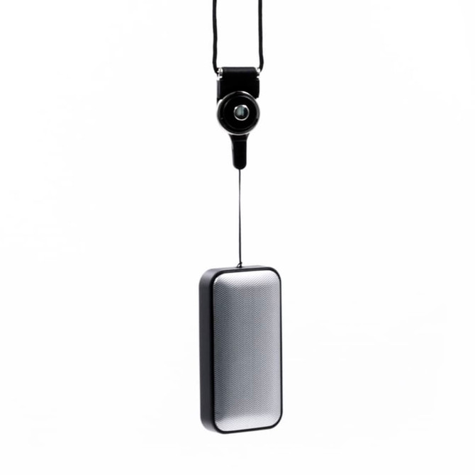 A sleek black and silver wireless speaker, with a hanging strap for easy attachment. It features a logo.