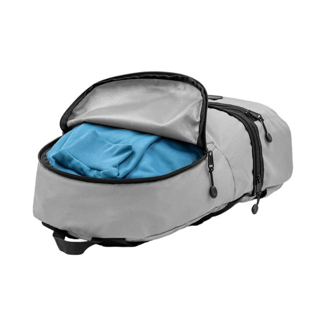 A grey bum bag with a partially open zipper revealing a blue shirt inside. It has a logo on the exterior.