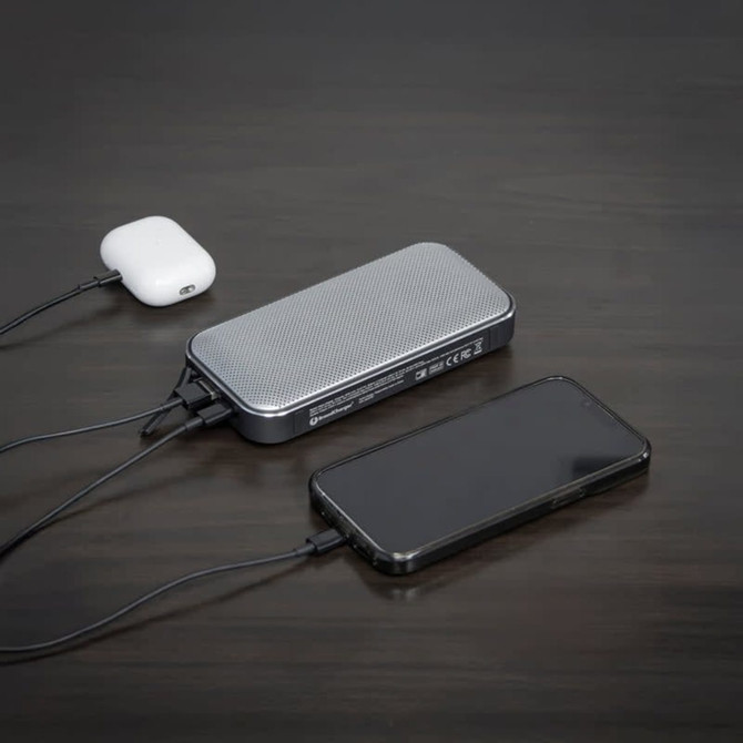 A Bluetooth speaker powerbank in silver and black, connecting to a smartphone and wireless earbuds.