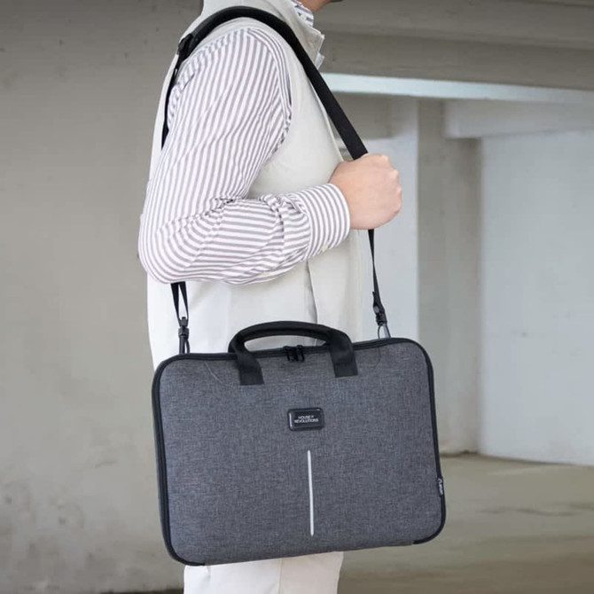 A grey laptop case with a shoulder strap and handle, featuring a logo.