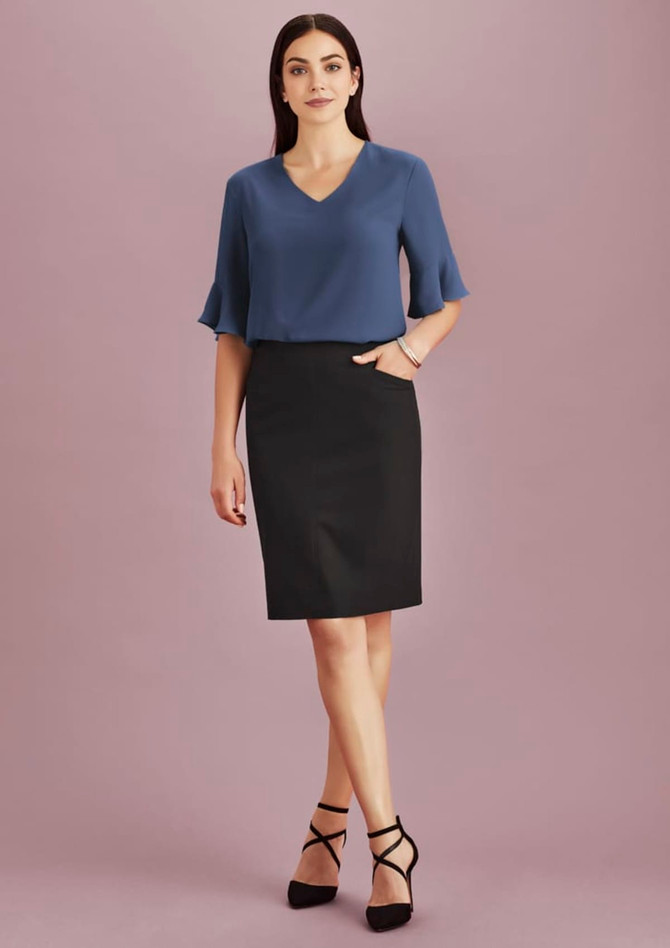 A model wearing a women's pencil skirt in black paired with a blue top, featuring a pocket and stylish heels.
