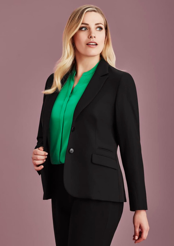 A black mid-length women's jacket is styled with a green blouse. The jacket features a fitted design and has a logo.