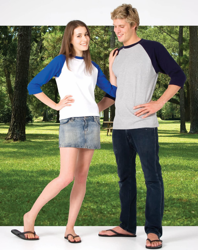 A woman in a white and blue 3/4 sleeve raglan T-shirt and a man in a grey T-shirt with navy sleeves stand outdoors.