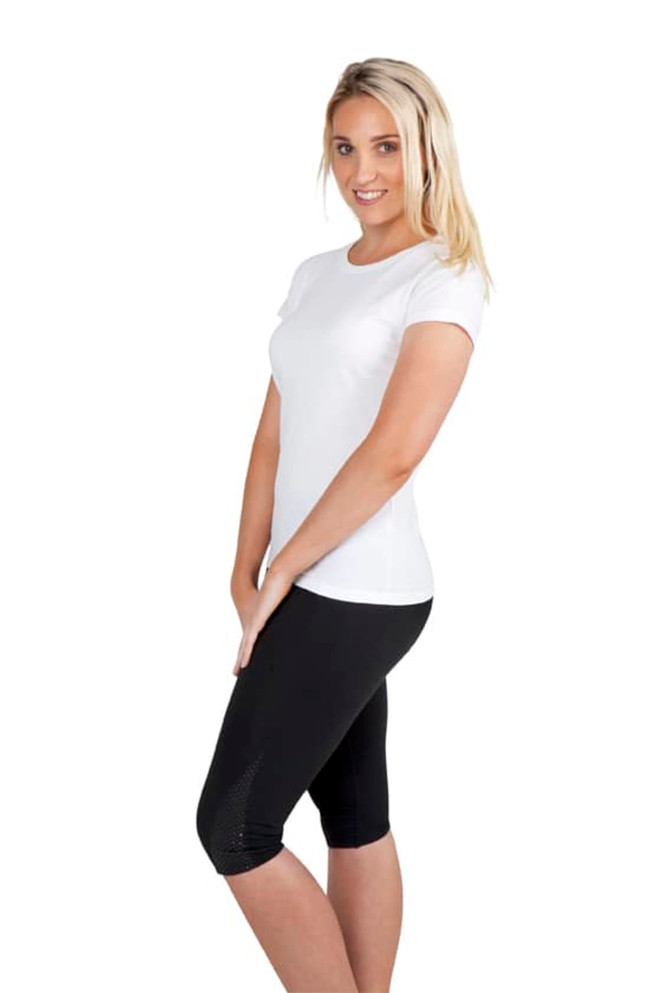 A woman poses in a white slim fit tee paired with black leggings. The tee features a simple design and has a logo.