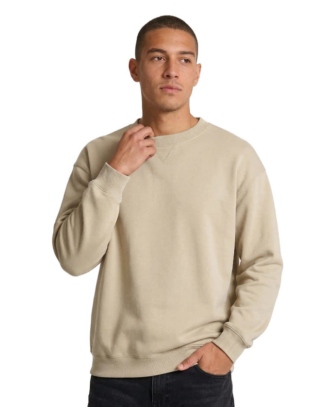 A woman wearing a light purple poly cotton fleece jumper with a relaxed fit. The jumper features a logo.