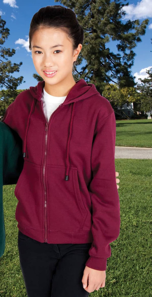 A young woman in a burgundy zipper hoodie with a pocket, standing outdoors against a grassy background.