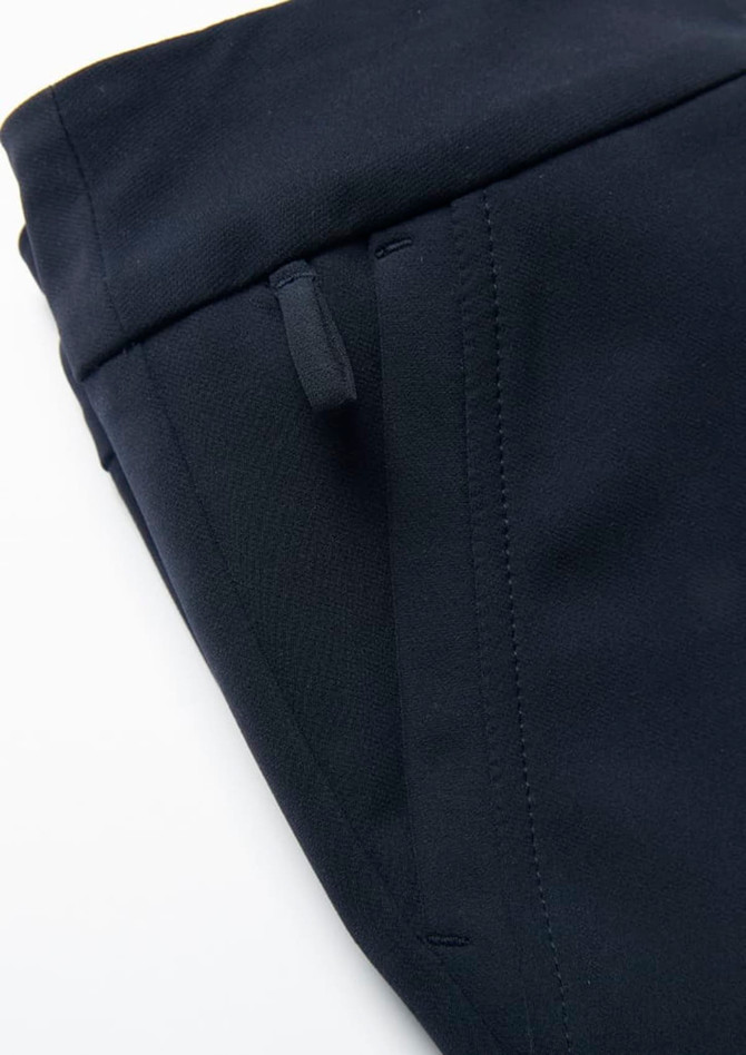A close-up of a navy women's stretch pant featuring side pockets and a smooth fabric finish.