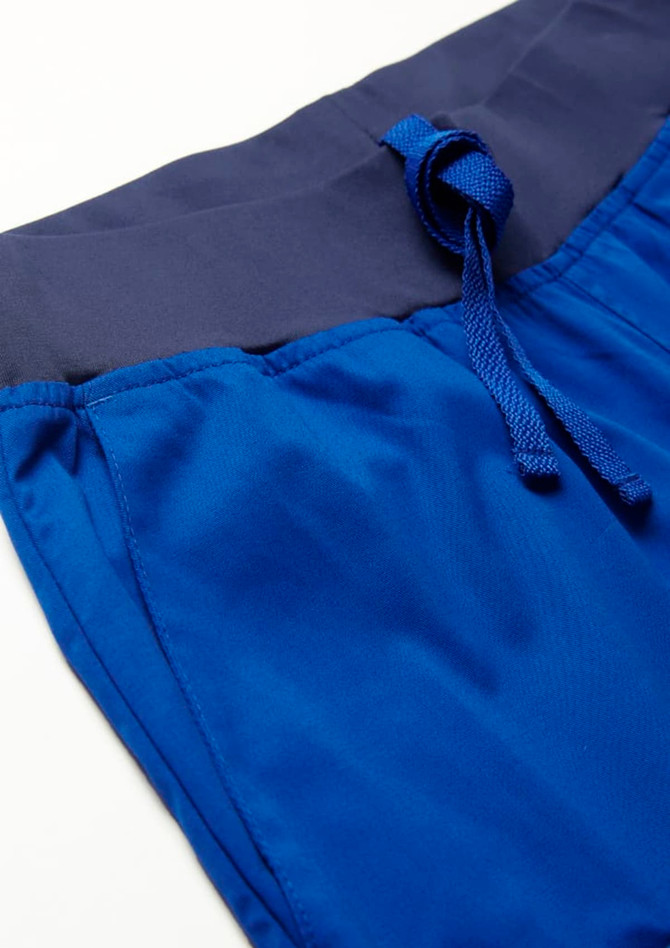 A close-up of blue jogger scrub pants featuring a navy waistband and drawstring.