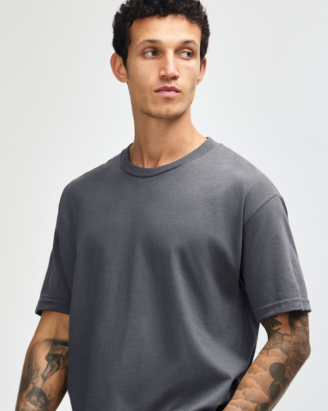 A heavyweight cotton unisex T-shirt in dark grey, featuring a round neckline and short sleeves. It has a logo.