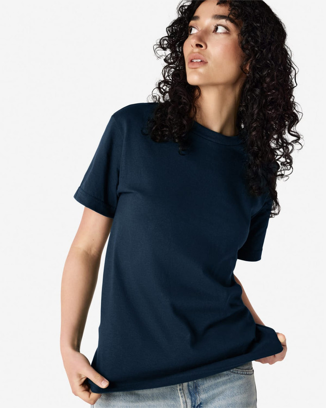 A navy heavyweight cotton unisex T-shirt is displayed, featuring a model with curly hair. The shirt has a logo.
