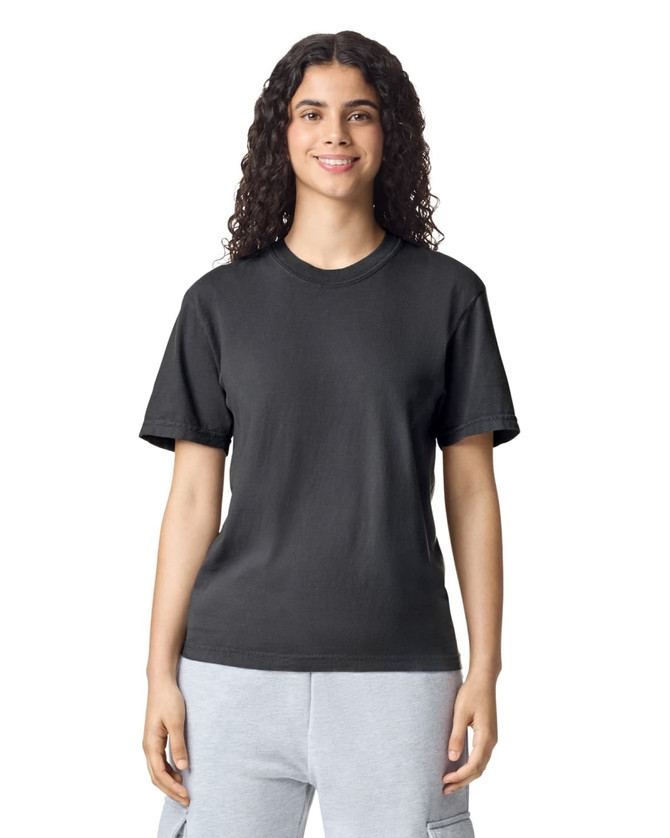 A black adult heavyweight T-shirt displayed on a smiling individual, featuring a round neckline and short sleeves.