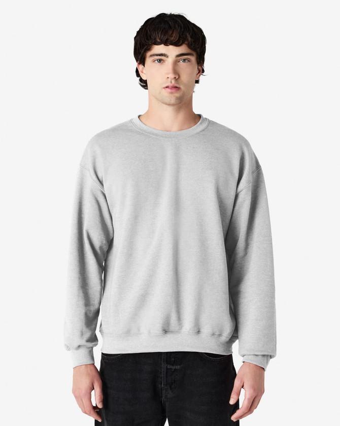A grey Gildan Heavy Blend adult crewneck sweatshirt displayed on a model, featuring long sleeves and a comfortable fit.