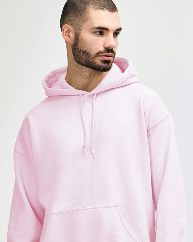 A model wearing a pink Gildan Heavy Blend Adult Hooded Sweatshirt with the hood up.