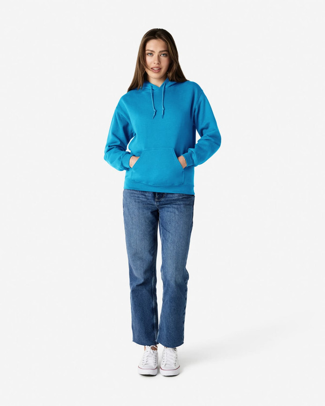 A woman in a bright blue hooded sweatshirt and jeans stands with her hands in the pockets.