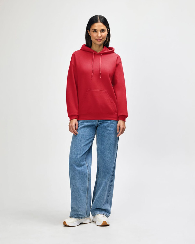 A red hooded sweatshirt worn by a model with jeans and sneakers, featuring a front pocket and drawstring hood.
