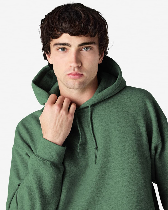 A green hooded sweatshirt with a large hood, featuring a logo, worn by a male model.