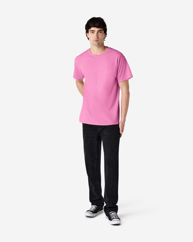 A pink Gildan Ultra Cotton adult T-shirt displayed on a model wearing black pants and shoes, featuring a logo.