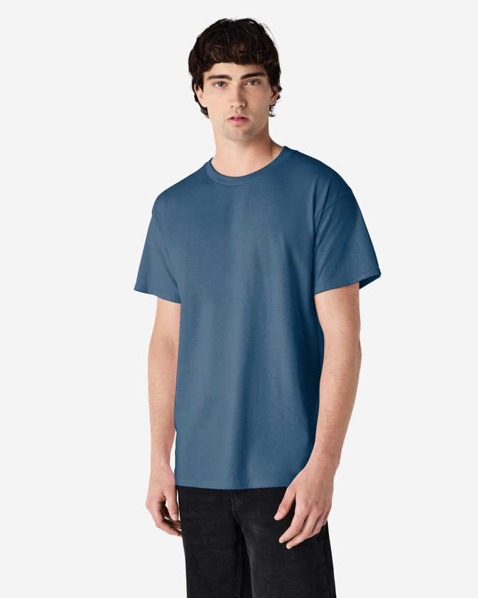 A man wearing a blue Gildan Ultra Cotton adult T-shirt, standing against a plain background.