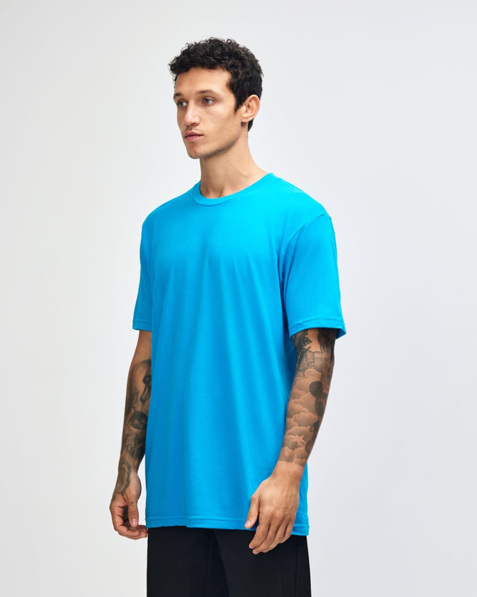 A unisex fine jersey short sleeve t-shirt in bright blue, displayed on a model from the side. It features a logo.