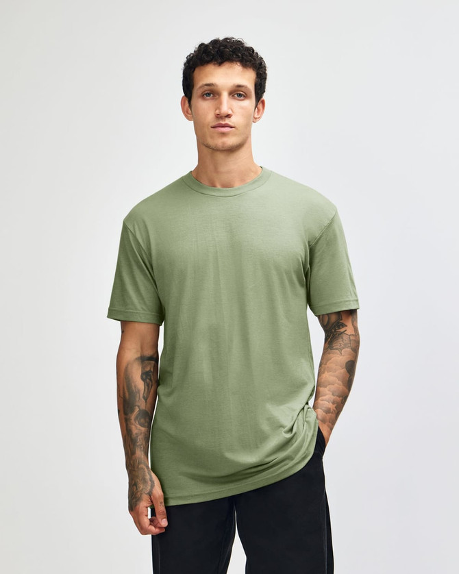 A plain green unisex CVC short sleeve T-shirt displayed on a model, featuring a subtle logo.