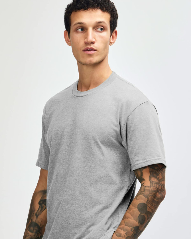 A grey unisex CVC short sleeve T-shirt displayed on a model with a plain background. It features a subtle logo.