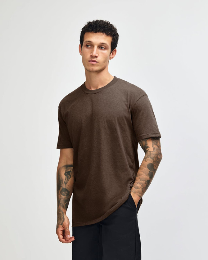 A unisex short sleeve T-shirt in brown, displayed on a model standing against a plain background. It features a logo.
