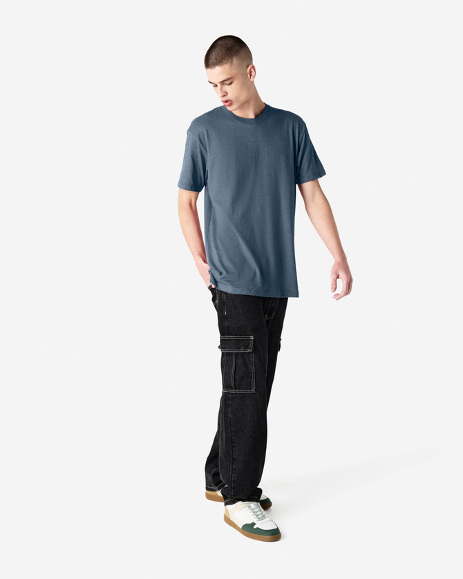 A short sleeve unisex t-shirt in a blue shade, paired with black cargo pants, featuring a logo.
