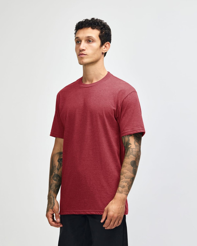 A unisex short sleeve t-shirt in a red hue, displayed on a model with a minimalistic background, featuring a logo.