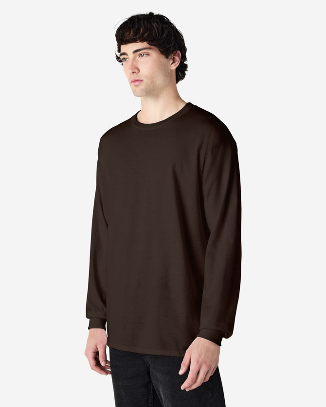A long sleeve T-shirt in dark brown worn by a model, featuring a simple design and logo.