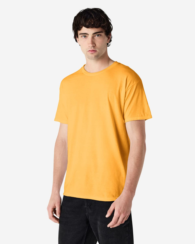 A model wearing a bright yellow Gildan Heavy Cotton adult T-shirt, standing against a plain background.