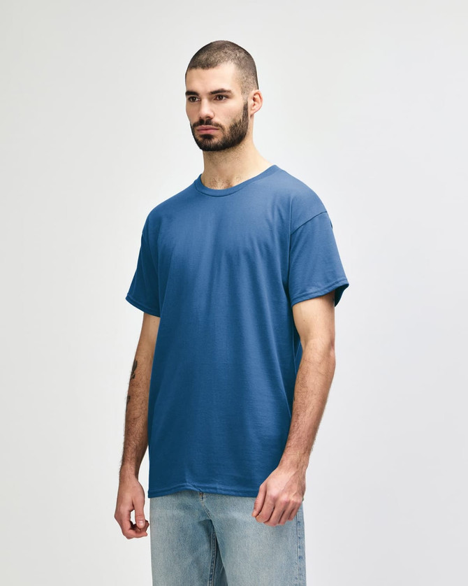 A blue Gildan Heavy Cotton adult t-shirt displayed on a model, featuring a simple design and a logo.