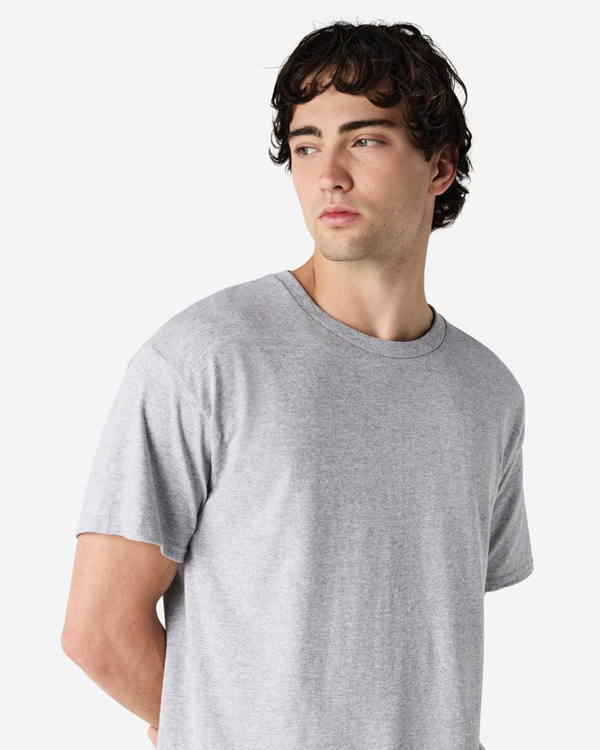 A grey Gildan Heavy Cotton Adult T-Shirt displayed on a model, featuring a simple design and a logo.