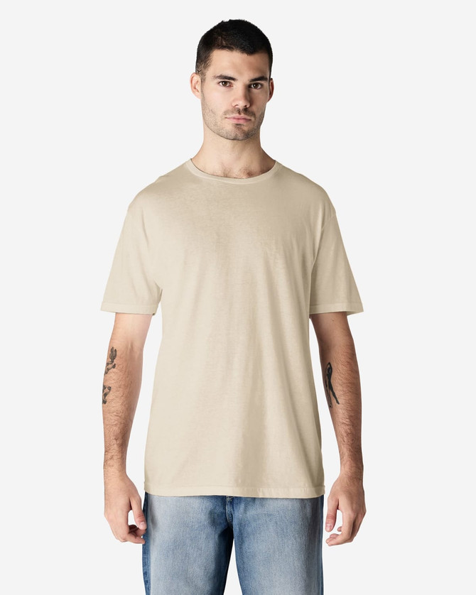A beige adult t-shirt is displayed worn by a male model, featuring a simple design and short sleeves.